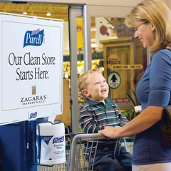 Purell hand sanitizer station in grocery store dispenses free sanitizer wipes