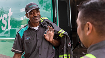 UniFirst Route Service Representatative, Keith, is delivering customized flame resistant uniforms with enhanced visibility striping to a customer and stops for a moment to answer a question for one of the uniform wearers.