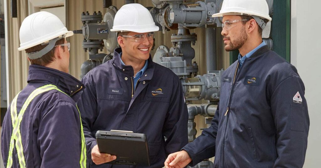 Workers wearing flame resistant, customized uniforms from a uniform rental programs