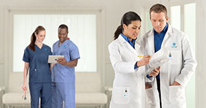 Healthcare employees wearing lab coats and scrubs