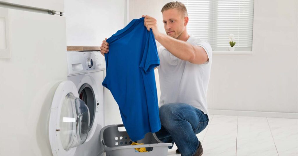 Man washing work clothing at home