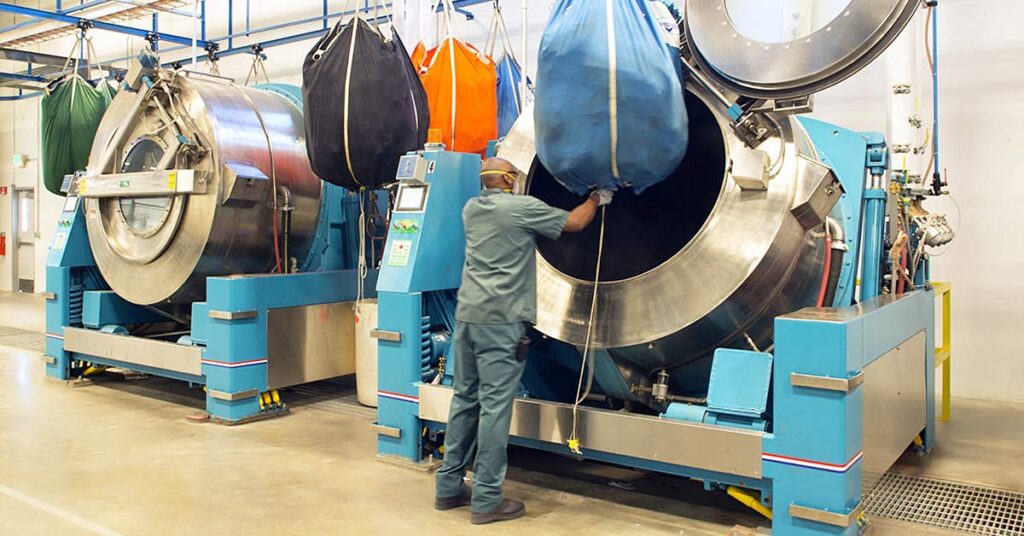 Uniforms being hygienically cleaned in industrial washers at a UniFirst laundering facility
