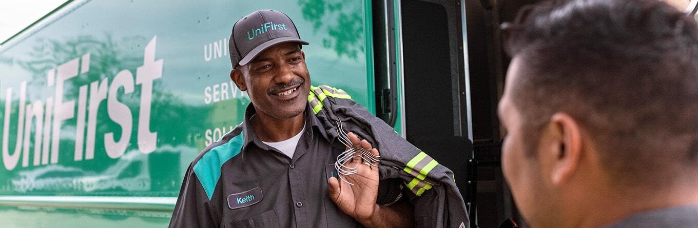 UniFirst Route Service Representatative, Keith, is delivering customized flame resistant uniforms with enhanced visibility striping to a customer and stops for a moment to answer a question for one of the uniform wearers.