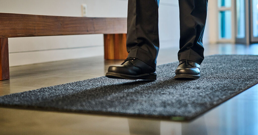 Close-up of a UniFirst floor mat on the floor of a business lobby.