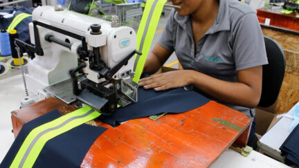 UniFirst manufacturing facility production worker creating customized uniforms and workwear.