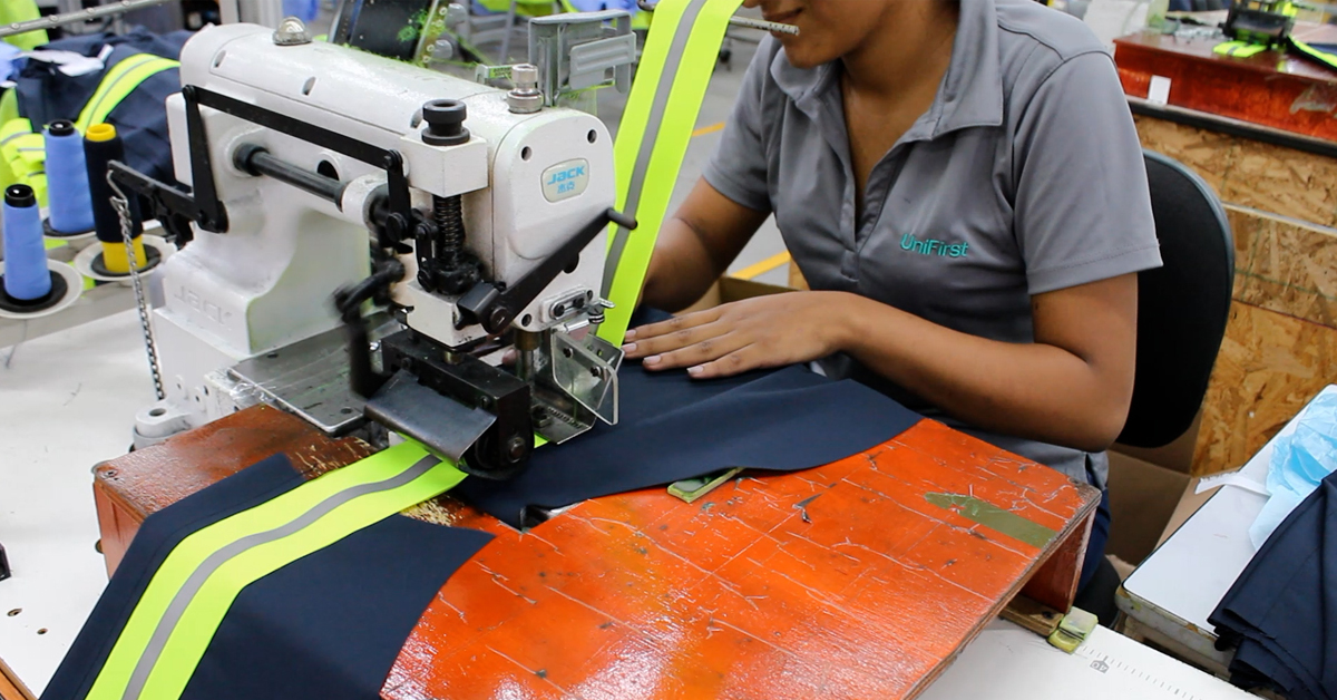 UniFirst manufacturing facility production worker creating customized uniforms and workwear.