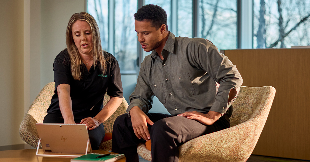 Discover the UniFirst Customer Portal – a UniFirst representative sits with a customer at a tablet