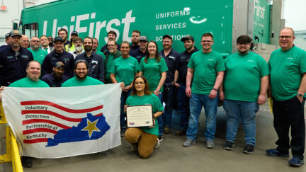The UniFirst Owensboro Safety Team proudly displays the VPP Star Certification OSHA flag.