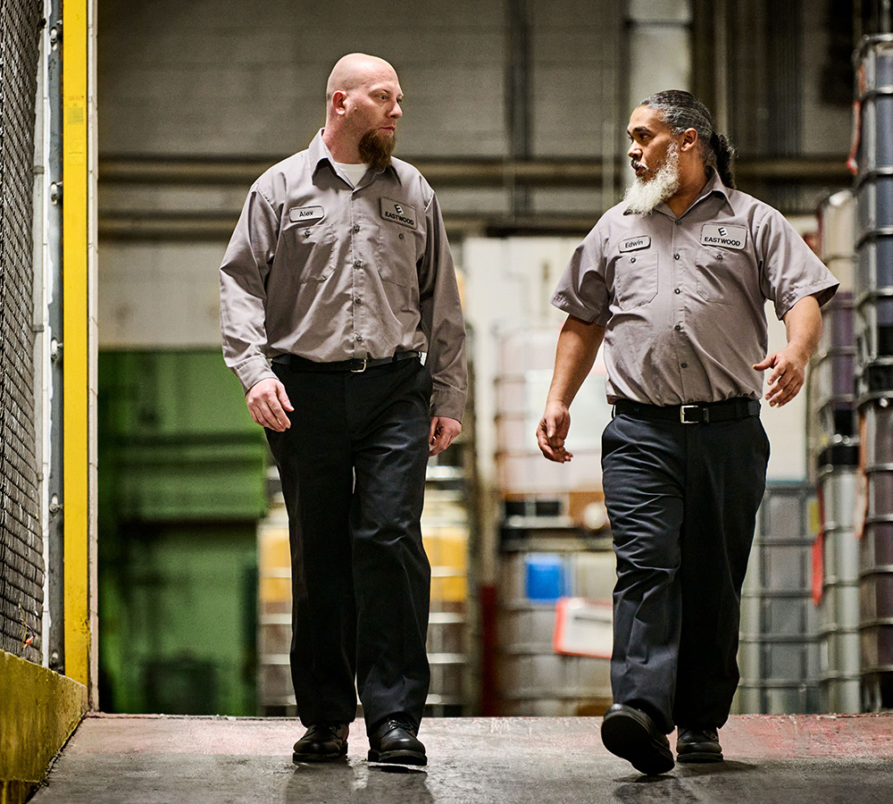 Automotive manufacturing workers walking down ramp wearing UniFirst uniform pants and shirts.