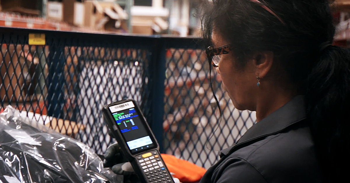 UniFirst Team Partner scanning product at a UniFirst location and how tariffs could impact uniform costs