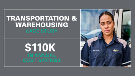 Woman working in the transportation and warehousing industry standing in front of a truck wearing UniFirst workwear