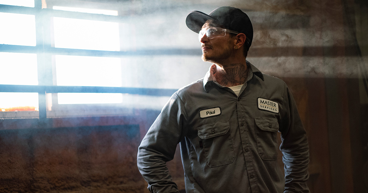 Worker in early morning wearing flame resistant workwear.