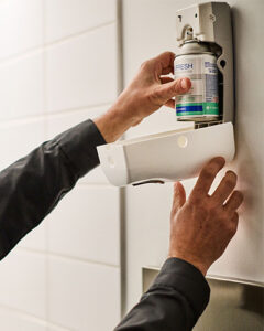 UniFirst route service representative replacing a restroom air freshener