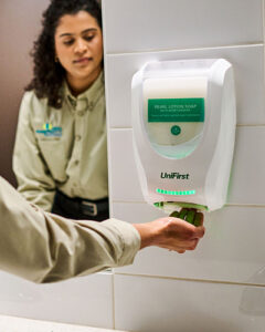 Women using commercial hand soap at a restroom sink