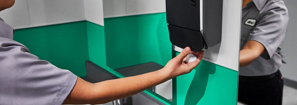 Woman using soap dispenser