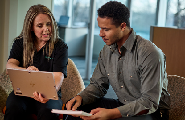 A UniFirst representative meets with a customer and discusses service