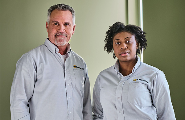 Two workers in UniFirst uniforms that are appropriate for their role keeping control on tail spend
