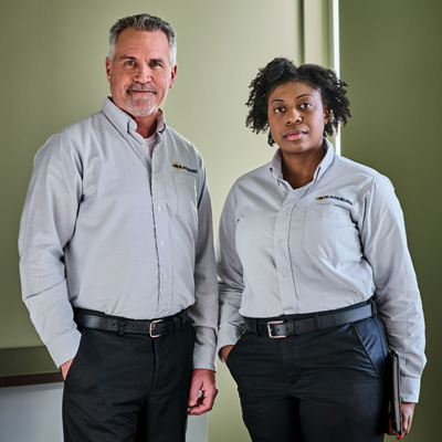 Two workers in UniFirst uniforms that are appropriate for their role keeping control on tail spend