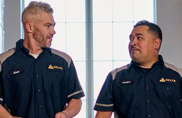 Two men walking together at work while wearing professional looking uniforms