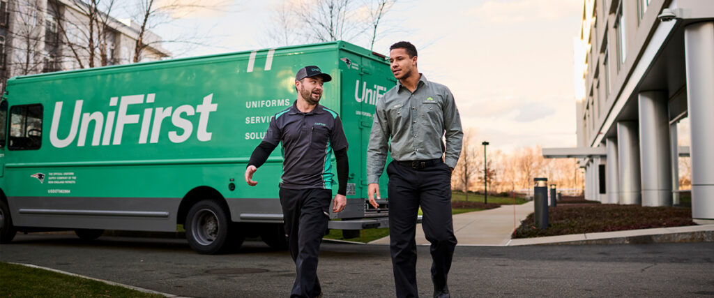 A UniFirst RSR and customer walking and chatting about facility managment