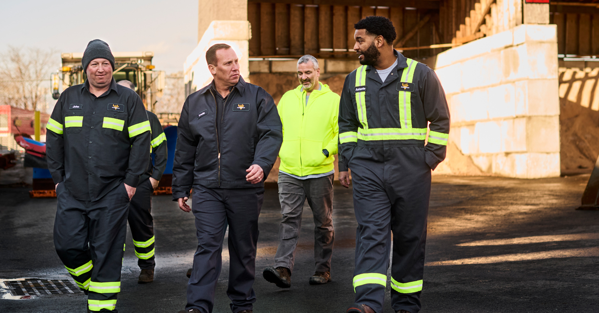 A group of workers at a work site wearing uniforms as part of a uniform rental service