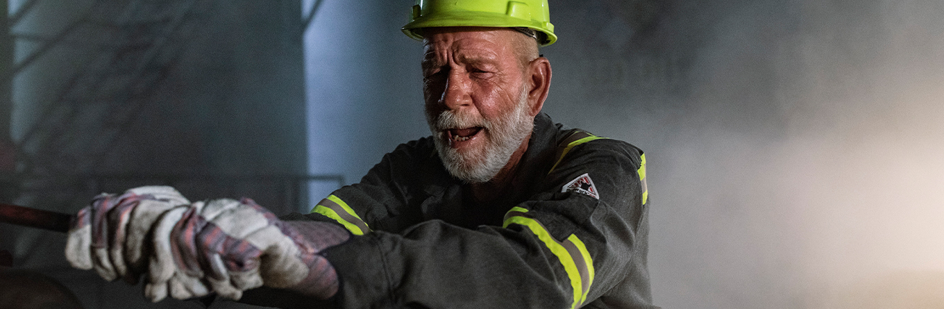 A man working in an oil field wearing PPE and UniFirst flame resistant clothing