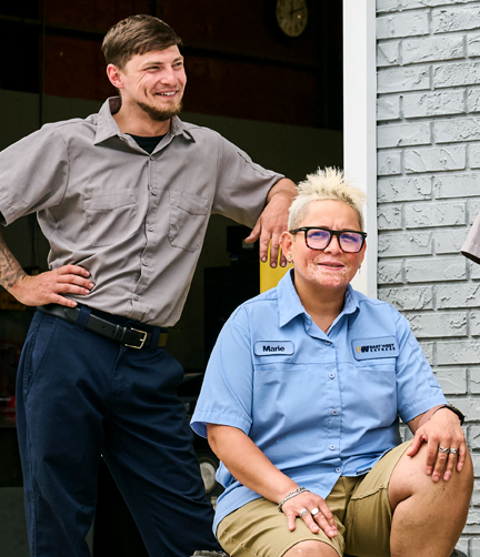 Two workers standing and sitting in comfortable workwear while on the job